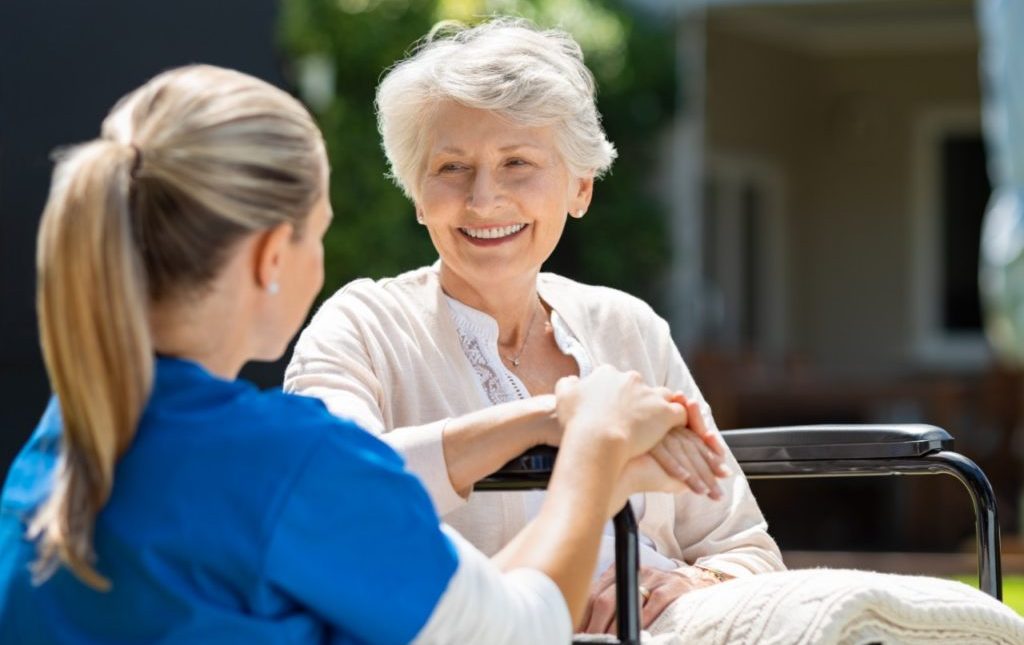 Active Senior sitting with a nurse potentially discussing, Providence House Assisted Living