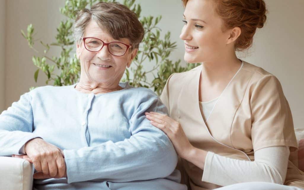 Active Senior sitting with a nurse potentially discussing, and praising Providence House Assisted Living