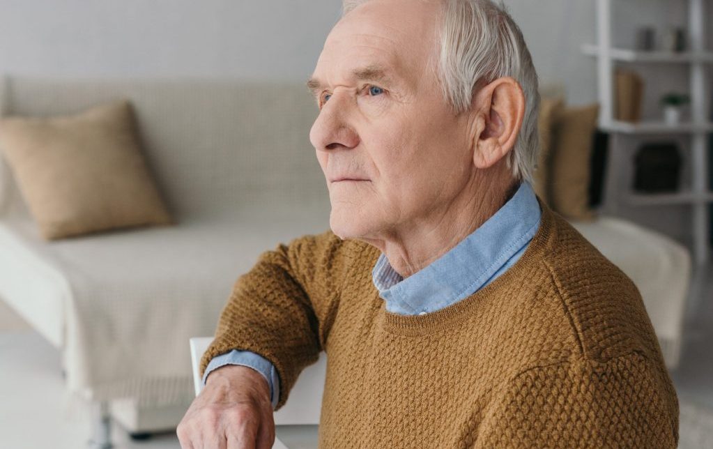 Active Senior sitting potentially thinking of, and experiencing Providence House Assisted Living Facility