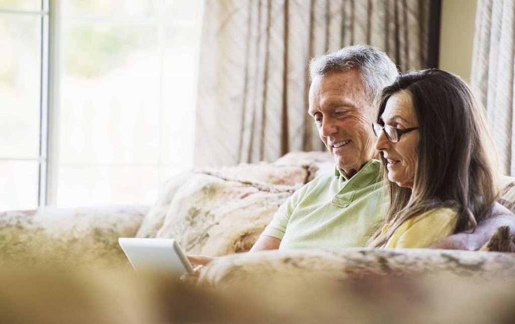 A Senior Couple using an Ipad to potentially look up Assisted Living Blogs such as Providence House Assisted Living
