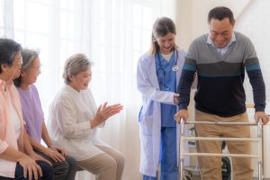 nurse supporting a senior surrounded by family in moving