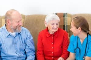 Elderly woman and her son at speaking to a caregiver.